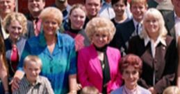 Cast of EastEnders posing together outside the iconic pub, featuring key characters and a loyal dog.