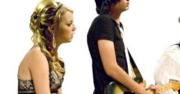 A young woman in a black dress sits next to a guitarist, set against a simple background, reminiscent of "The Rocker.