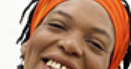 Miss Cleo smiling with vibrant orange headwrap and colorful attire, embodying her captivating psychic persona.