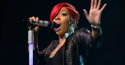 K. Michelle passionately performs on stage, showcasing her dynamic stage presence during her "Anybody Wanna Buy a Heart?" tour.