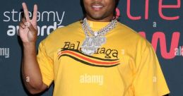 Excited attendee at the Streamy Awards wearing a bright yellow Balenciaga shirt, flashing a peace sign on the red carpet.