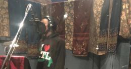 Playboi Carti in a studio session at Medusa, recording with a microphone, wearing a vibrant outfit and relaxed vibe.