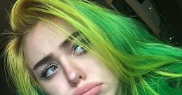 Young content creator with vibrant green and yellow hair, expressing a thoughtful mood. Perfect for RUS Feofilov fans.