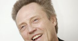 Christopher Walken smiling in a casual jacket with a playful expression, showcasing his unique charisma and iconic style.