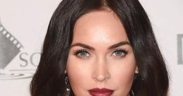 Megan Fox showcasing stunning makeup with bold lips and glamorous hairstyle at a red carpet event.