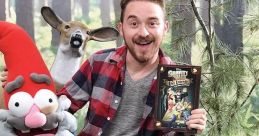 Alex Hirsch, smiling with a gnome puppet and "Gravity Falls" book, surrounded by woodland décor and playful props.