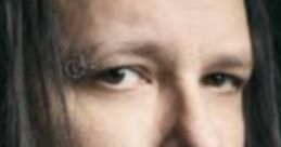 Close-up portrait of Jonathan Davis with long dark hair and piercing eyes, expressing intensity and focus.