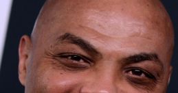 Charles Barkley smiling at an event, showcasing his charismatic personality and signature bald look.