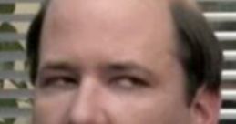 Kevin Malone looking skeptical in a business suit, showcasing his classic deadpan humor from the iconic TV show "The Office.