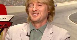 Owen Wilson smiling during an interview about Lightning McQueen from Pixar's Cars, showcasing his signature charm.