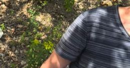 Person sitting outdoors, wearing a striped shirt, surrounded by greenery, conveying a sense of unease and landlord tension.