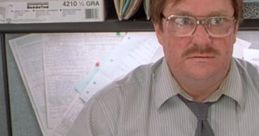 Frustrated office worker surrounded by paperwork, embodying the humor of "Office Space" (1999) in a cubicle setting.