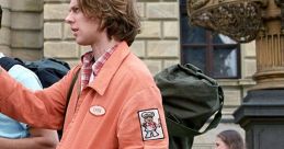 Casual traveler in an orange jacket navigates a busy street, reminiscent of adventures in EuroTrip (2004).