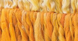 Vibrant strands of silk in shades of yellow and orange, showcasing the natural beauty and texture of silk fibers.