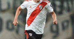 Fernando Fernandez dribbles the ball on the field wearing River Plate's iconic white and red jersey during a match.