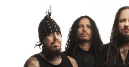 Korn band members pose in a studio, featuring distinctive tattoos and unique styles, capturing their iconic look.