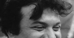 Uttam Kumar smiling joyfully, showcasing his iconic charm in a nostalgic black-and-white portrait.