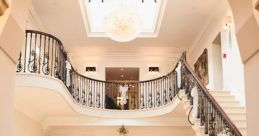 Elegant foyer of Old Down, featuring a grand staircase and decorative chandelier, perfect for events and gatherings.