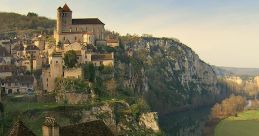 Scenic view of a medieval village on a cliff with a river, showcasing historical architecture and lush greenery.