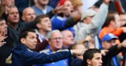 Chelsea fans passionately cheer and celebrate as a player scores, embodying the spirit of football club songs.