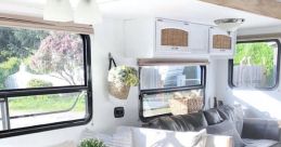 Cozy RV interior featuring a modern dining table, plush seating, and decorative accents for a comfortable travel experience.