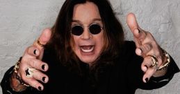 Ozzy Osbourne strikes a dramatic pose with outstretched hands, showcasing his iconic rock star style and captivating presence.