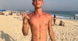 Young man with a confident pose on a sunny beach, wearing green shorts and showing a playful gesture, capturing summer vibes.