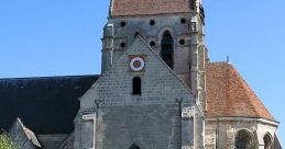 Charming old church with unique architecture and lush greenery, blending history and beauty in a sunny setting.