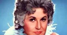 Bea Arthur posing elegantly in a light blue outfit, known for her iconic roles and views on marijuana advocacy.