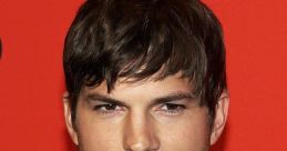 Ashton Kutcher at an event, showcasing his signature style with a sharp suit and confident expression against a vibrant backdrop.