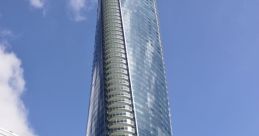 Modern glass skyscraper in Vancouver surrounded by urban architecture and greenery under a clear blue sky.