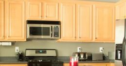 Modern kitchen featuring light wooden cabinets, stainless steel appliances, and a central island with bar stools.