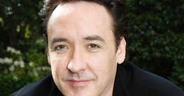 John Cusack smiles casually while wearing a black jacket, surrounded by greenery, showcasing a relaxed vibe.