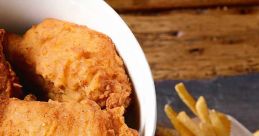 Crispy KFC fried chicken in a bucket, served with golden French fries on a rustic wooden table. Delicious fast food meal.