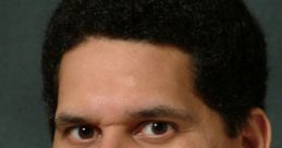 Reggie Fils-Aimé smiling, wearing a suit, known for his influential role at Nintendo and gaming industry leadership.