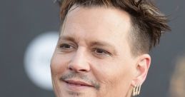 Johnny Depp smiling at a red carpet event, wearing a stylish suit with unique hair and accessories, showcasing his charisma.