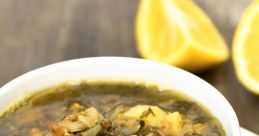 Delicious Hamod soup with greens, lentils, and potatoes, served with lemon slices for a refreshing twist.