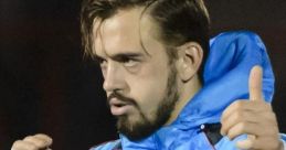 Trevor Phillips giving a thumbs-up, wearing a blue training jacket, showcasing confidence and determination on the field.