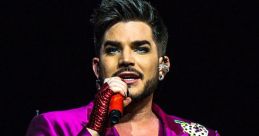 Adam Lambert performing on stage in a vibrant purple suit, showcasing bold fashion and captivating stage presence.