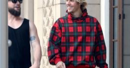 Justin Bieber in a casual plaid hoodie, walking and smiling with a friend on a sunny day. Stylish urban outfit.