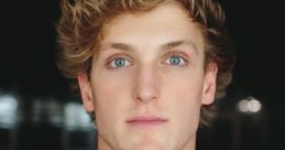 Logan Paul with tousled hair and striking blue eyes, wearing a blue tank top against a dark background.