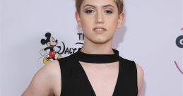 Young person in a stylish black outfit poses confidently at a Disney event celebrating 25 years of creativity and fun.