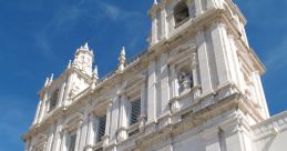 Baroque architecture featuring intricate sculptures and a grand façade against a clear blue sky. Elegant design details.