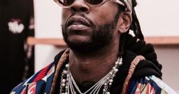 2Chainz showcasing his iconic style with layered chains and vibrant jacket, embodying hip-hop fashion trends.