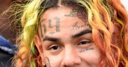 6ix9ine showcases his signature multicolored hair and tattoos, exuding his bold personality and unique style.