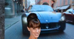 Stylish model in a blue dress poses beside a luxury car at an auto show, showcasing elegance and sophistication.