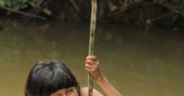 Awa child joyfully swinging on a stick over a river, showcasing traditional play and cultural heritage in nature.