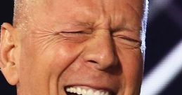 Bruce Willis laughing heartily, showcasing his joyful personality while dressed in a classic tuxedo.