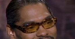 Pootie Tang smiling in stylish eyewear, showcasing his iconic look from the cult classic comedy film.