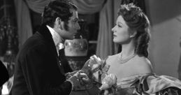 Greer Garson and Laurence Olivier in a romantic scene from the classic "Pride and Prejudice" film. Timeless elegance captured.